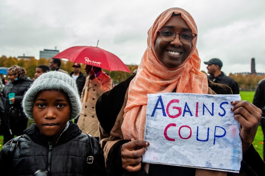 Kvinne og barn med plakat demonstrerer mot militærkupp i Sudan, markering i Nederland. 